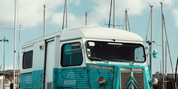 pexels-photo-25471385-25471385 Classic Citroen H Van parked at a marina in Lisbon, Portugal under clear blue skies.